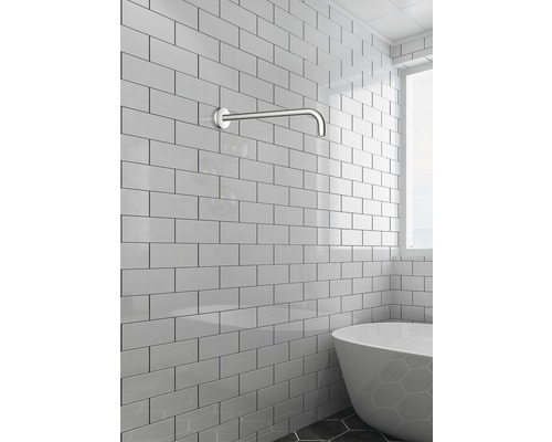 Salle de bains avec bras mural pour baignoire et carreaux blancs