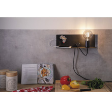 Étagère murale avec lampe, smartphone, horloge et décoration dans une scène de cuisine.