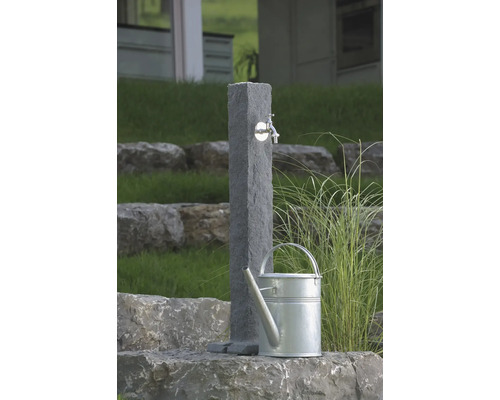 Scène de jardin avec point d''eau en pierre et arrosoir