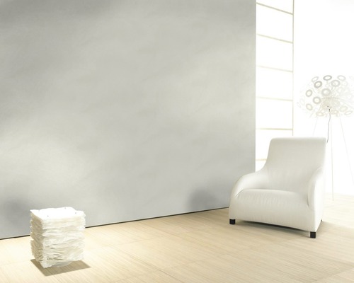 Pièce lumineuse avec fauteuil, lampe et murs structurés