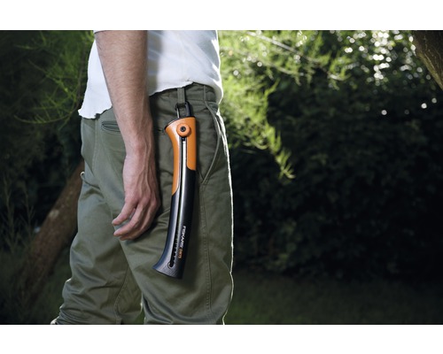 Mann mit Fiskars Handsäge in der Hosenbefestigung im Garten