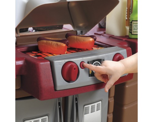 Spielküche mit Grill und Würstchen, bedient von Kinderhand
