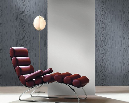 Ambiance de pièce avec un fauteuil et un lampadaire devant un revêtement mural à aspect de veinure de bois