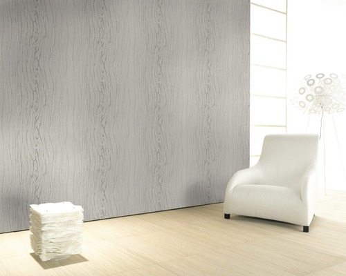 Pièce lumineuse avec papier peint à structure bois, fauteuil et lampe.