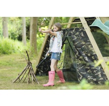 Mädchen zielt mit Pfeil und Bogen auf einem Spielplatz mit Tarnzelt und Holzkonstruktion