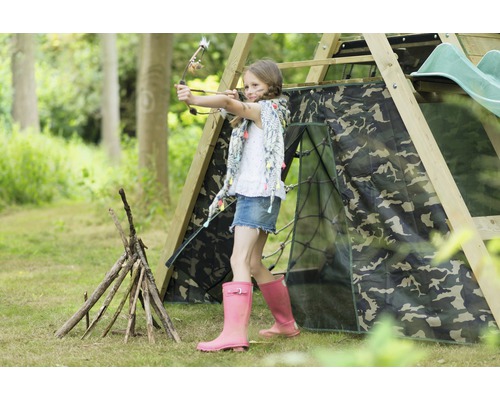 Mädchen zielt mit Pfeil und Bogen auf einem Spielplatz mit Tarnzelt und Holzkonstruktion