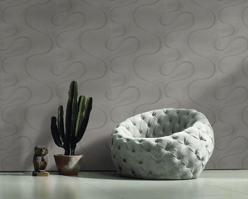 Salon avec papier peint à motifs, fauteuil, cactus et décoration