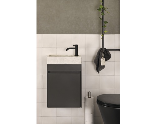 Salle de bains avec meuble sous-lavabo, robinet, serviette et toilettes