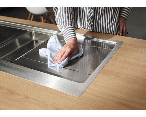 Évier en acier inoxydable sur plan de travail nettoyé avec un chiffon