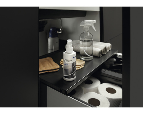 Meuble bas coulissant avec produit de nettoyage, vaporisateur, chiffons et papier toilette