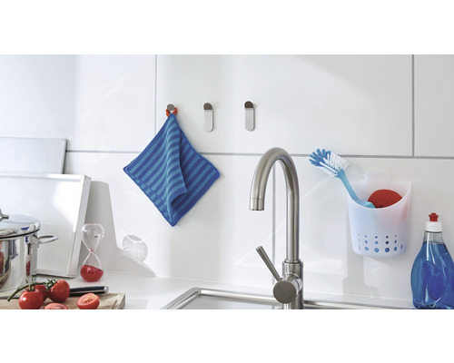 Küchenszene mit Spültisch, Armatur, Handtuch und Spülutensilien.