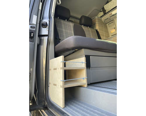 Innenraum eines Vans mit einer Holzstufenleiter vor einem Sitz