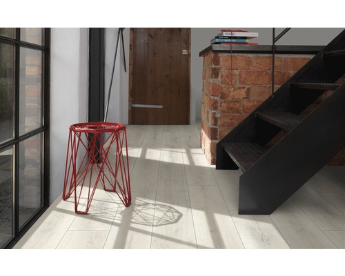 Hall d''entrée clair avec tabouret rouge, escalier et porte en bois
