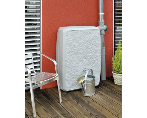 Wassertank mit Wasserhahn, Giesskanne und Gartenstuhl auf einer Terrasse