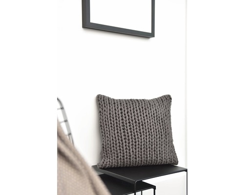 Dekokissen mit Strickmuster auf einem Tisch