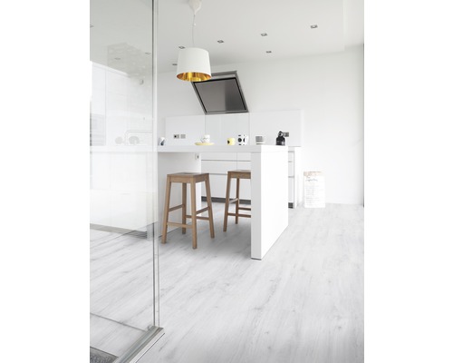 Cuisine claire avec îlot de cuisine, tabourets de bar et plancher en bois