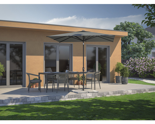 Gartenmöbel-Set mit Tisch, Stühlen und Sonnenschirm auf einer Terrasse vor einem Haus