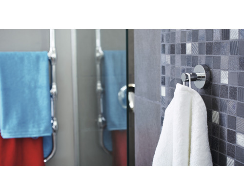 Salle de bain avec porte-serviettes et serviettes sur mur en mosaïque