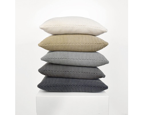 Stapel aus fünf gestrickten Kissen auf einem Sockel