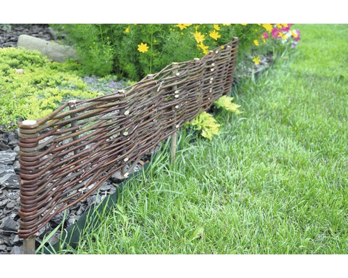 Scène de jardin avec une basse clôture en branches tressées