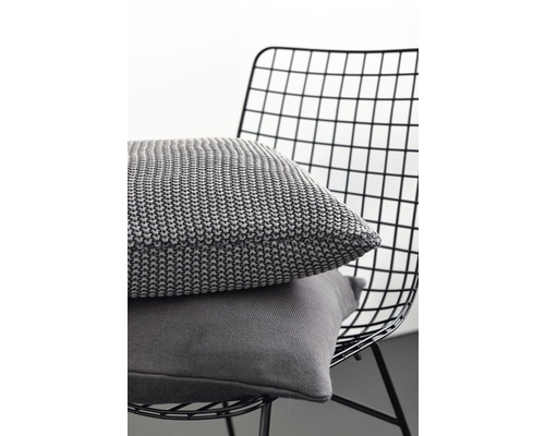 Zwei graue Kissen auf einem Drahtstuhl