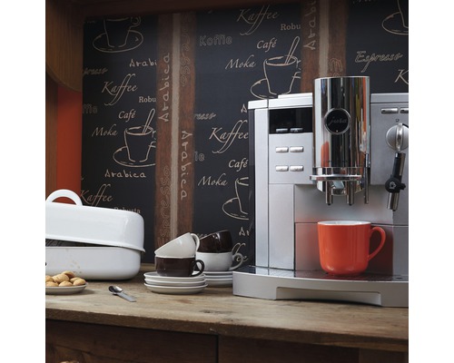 Szene mit einem Kaffeevollautomaten der Marke Jura, Tassen und Gebäck auf einem Holztisch