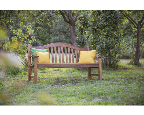 Banc de jardin en bois avec coussins sur une pelouse
