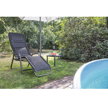 Scène de jardin avec une chaise longue, un parasol et une petite table avec des boissons et une pastèque.