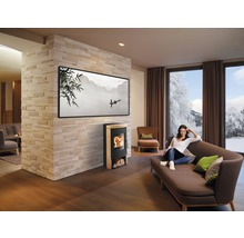 Espace de vie lumineux avec poêle à bois, canapé et femme