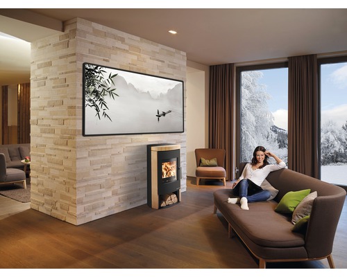 Espace de vie lumineux avec poêle à bois, canapé et femme