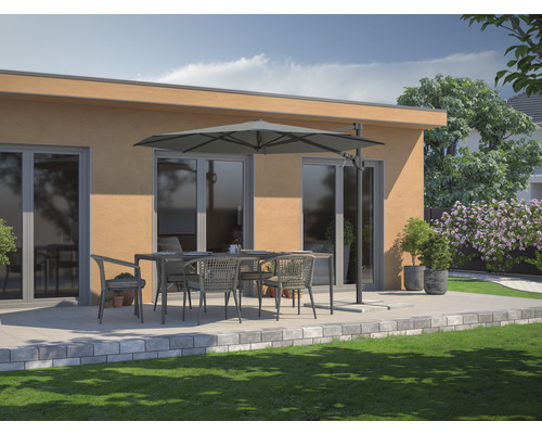 Scène de terrasse avec table à manger, chaises et parasol devant un bâtiment