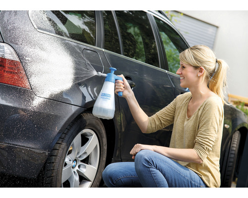 Femme nettoie la voiture avec le pulvérisateur de mousse Gloria