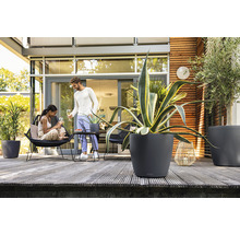 Terrasse mit Pflanzkübeln und entspannten Personen