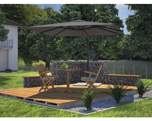 Gartenszene mit Sonnenschirm, Holzboden, Tisch, Stühlen und Gabionenmauer