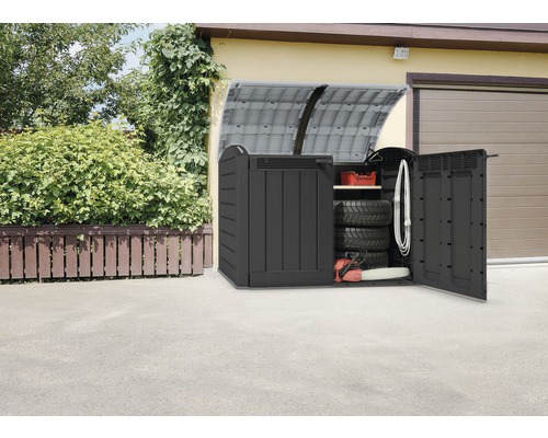 Geöffnete Gerätebox aus Kunststoff mit Zubehör vor einer Garage