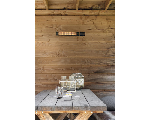 Scène avec chauffage radiant sur un mur en bois au-dessus d''une table en bois