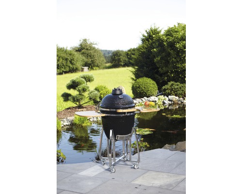 Keramikgrill auf Rädern im Garten mit Teich