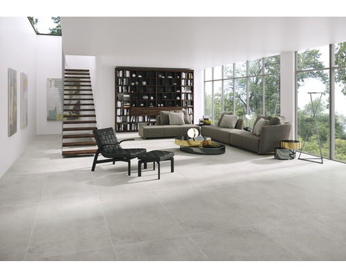 Pièce lumineuse avec carrelage, coin salon et escalier