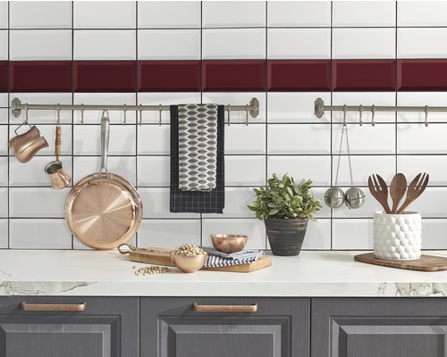 Küchenszene mit weißen Fliesen, Küchenutensilien und Dekorationen auf einer Arbeitsplatte