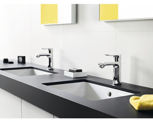 Badezimmer mit zwei Waschbecken und verchromten Armaturen auf einer dunklen Arbeitsplatte