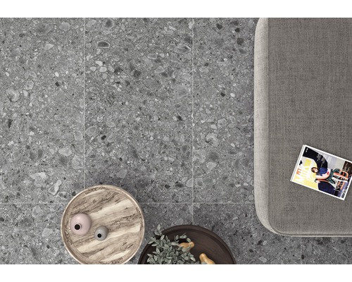 Graue Feinsteinzeugfliesen im Innenraum mit Couch, Tisch und Zeitschrift