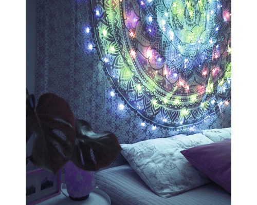 Chambre à coucher avec une tenture murale et une guirlande lumineuse pour un éclairage d''ambiance