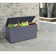 Coffre de jardin ouvert avec outils de jardinage et coussins d''assise devant un mur