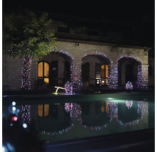 Maison en pierre avec jardin, éclairée par une guirlande lumineuse