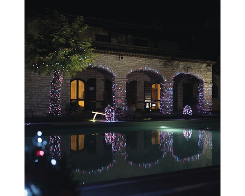 Maison en pierre avec jardin, éclairée par une guirlande lumineuse