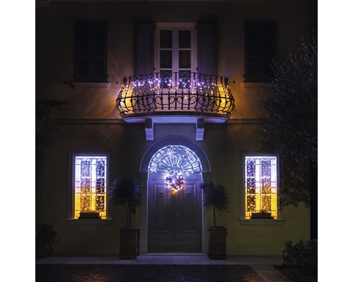 Façade de maison avec fenêtres, balcon et porte d''entrée, décorée de guirlandes lumineuses pour Noël