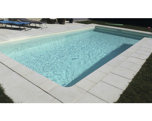 Piscine avec bordure en pierre dans le jardin