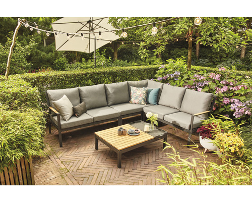 Ensemble de meubles de jardin avec canapé d''angle, table et parasol dans un jardin luxuriant