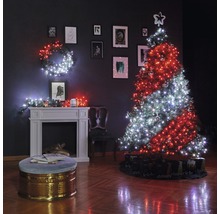 Pièce décorée pour Noël avec sapin, guirlandes lumineuses, cheminée et décorations.