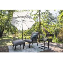 Szene mit Sonnenschirm, Sessel, Hocker und Beistelltisch auf einer Terrasse